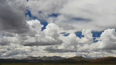 Karlı tepe ve mavi gökyüzü bulutlu Himalaya Dağları Tibet'te