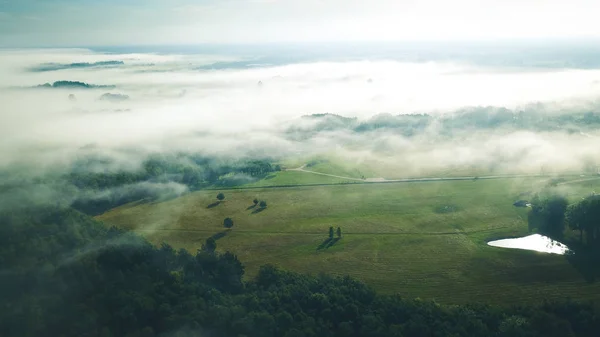 Misty sunrise over countryside path Aerial view Latvia