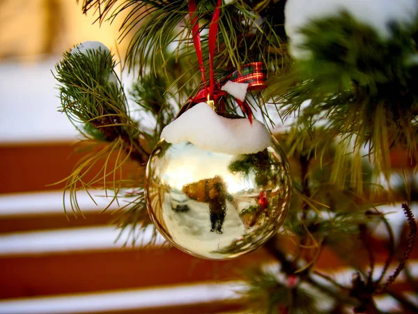 Weihnachtsdekoration. goldene Weihnachtskugel und grüner Fichtenzweig — Stockfoto
