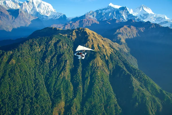 Ultralight aircraft and trees and snowcapped peak at background in the Himalaya mountains, Nepal — Stock Photo, Image