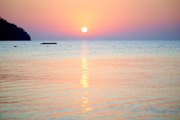 Naranja puesta de sol sobre el mar con barco increíble reflejo dorado del sol en las olas tranquilas — Foto de Stock