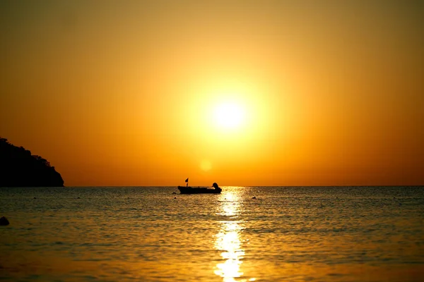 Tramonto arancione sopra il mare con barca stupefacente Riflesso dorato del sole sulle onde calme — Foto Stock