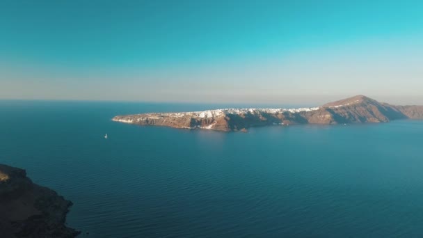 Воздушный дрон видео песчаного пляжа голубой морской воды, чистое голубое небо острова Киклады, Санторини Греции — стоковое видео