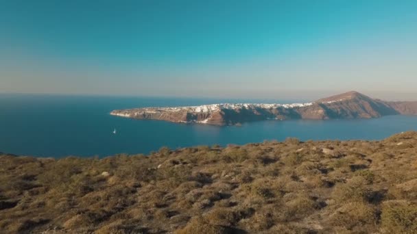 Video pesawat tak berawak dari air laut pantai biru berpasir, pulau langit biru yang jernih Cyclades, Santorini Yunani — Stok Video
