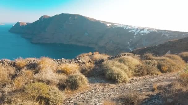 在希腊圣托里尼岛，空中无人飞机拍摄的沙滩蓝海水、蓝天环形山的视频 — 图库视频影像