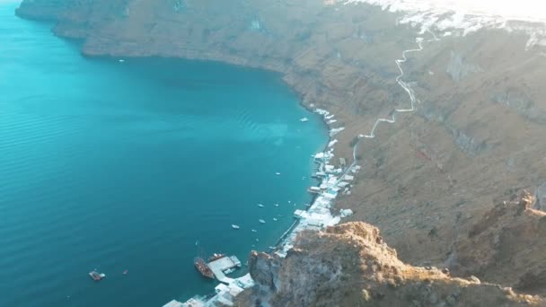 Воздушный дрон видео песчаного пляжа голубой морской воды, чистое голубое небо острова Киклады, Санторини Греции — стоковое видео