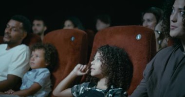 Yavaş çekim Genç bir aile birlikte bir film izlerken bir sinema oturan geçmiş izleme