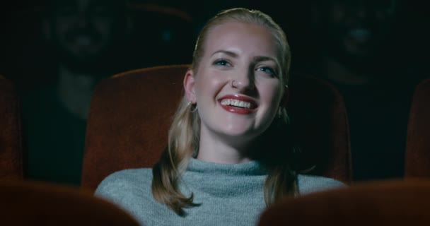 一个美丽的年轻女人在电影院里笑着笑 — 图库视频影像