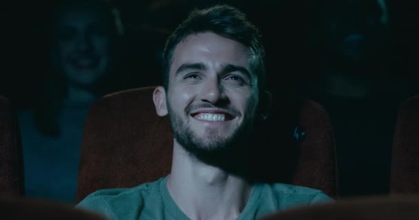 Jonge Man Zitten Een Bioscoop Glimlachen Lachen Een Grappig Moment — Stockvideo