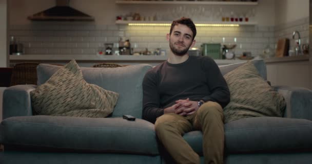 Junger Mann Entspannt Auf Einer Couch Vor Dem Fernseher Lächelt — Stockvideo