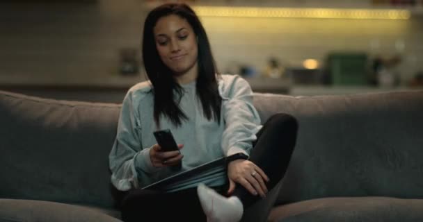 Žena Sedí Pohovce Kříže Nohy Zapne Televizi Pomocí Dálkového Ovládání — Stock video