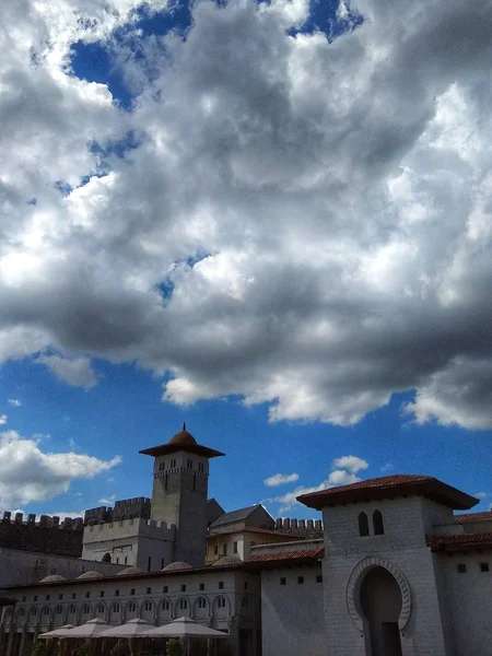 Medieval castle. Blue sky. The sun's rays pass through the clouds.