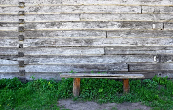 Staré Dřevěné Lavičce Stojící Trávě Pozadí Dřevěné Stěny — Stock fotografie