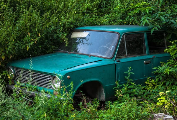old Soviet car abandoned in the weeds for your design
