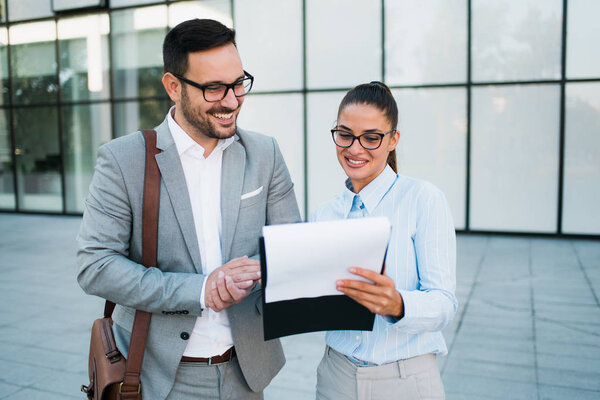 Красивый молодой бизнесмен и деловая женщина улыбаются и говорят о бизнес-идеях и обсуждают бизнес-планы
.