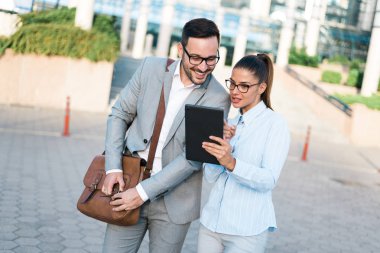 Söz, birlikte bir iş merkezi önünde ayakta dışında tablet ve iş planları kullanarak çalışan genç iş adamları.