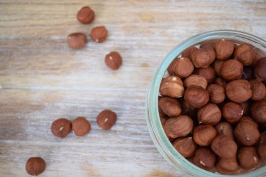 Fındık bir cam kavanoz ve dağınık fındık ağaç arka planda. Kopya alanı.