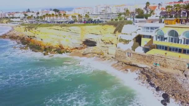 在葡萄牙卡斯卡伊斯 在阳光明媚的日子里 在葡萄牙的卡斯卡伊斯 空中无人机查看大西洋海岸 无人机拍摄海浪击中岩石 在葡萄牙海岸的城市景观和海滩的背景 — 图库视频影像