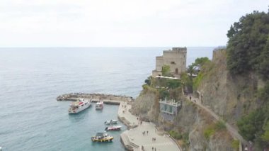 Aerial View, İtalya, Dağlar, Ligurian Denizi, Cinque Terre, Monterosso al Mare. Peninsula 'nın etrafında uçarak sahile, okyanusa, plaja ve teknelere bakıyorum. 4 K video