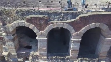 İtalya, Arena di Verona 'nın hava panoramik manzarası. İnsansız hava aracı duvarın ve Arena 'nın kemerlerinin yanında uçuyor. Arena manzarası ve şehir açılıyor. 4k görüntüleme.