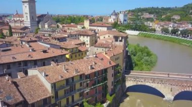 İtalya, Verona 'nın panoramik hava aracı görüntüsü. İnsansız hava aracı, tipik bir İtalyan apartmanı olan Adige nehrinden uzaklaşır ve Ponte Pietra ile köprü kurar. 4K içinde video