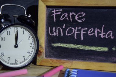 İtalyanca un'offerta ifade renkli yazı tahtası üzerinde el yazısı üzerinde servis eder. Eğitim ve iş kavramı. Çalar saat, tebeşir, siyah arka plan üzerine kitaplar