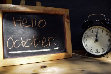 Ekim Merhaba. Geri okul kavramı. Çalar saat ahşap arka plan tahtaya ile