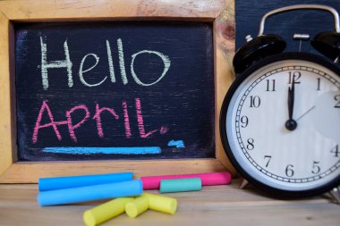 Merhaba Nisan. Geri okul kavramı. Çalar saat ahşap arka plan tahtaya ile