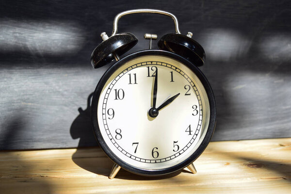 2 am/pm Back to school concept. Alarm clock on wooden with blackboard on background