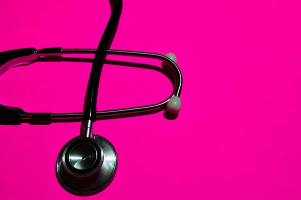 stethoscope with healthcare concept on pink background