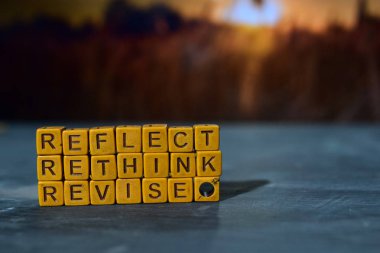 Reflect - Rethink - Revise on wooden blocks. Cross processed image with bokeh background clipart