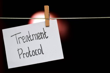 Tedavi protokolü el yazısı kağıt üzerinde. Bir elbise klipleriyle astı tıbbi ve eğitim kavramı. ışık arka plan bulanıklık