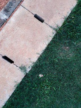 Çimento drenaj rendeleyin arka plan ile çapraz ve yeşil çimen