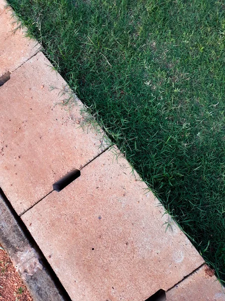 Çimento drenaj rendeleyin arka plan ile çapraz ve yeşil çimen