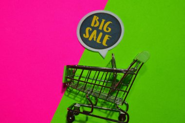 Büyük satış metin ve alışveriş sepeti. Renkli arka plan üzerinde indirim ve promosyon iş kavramı