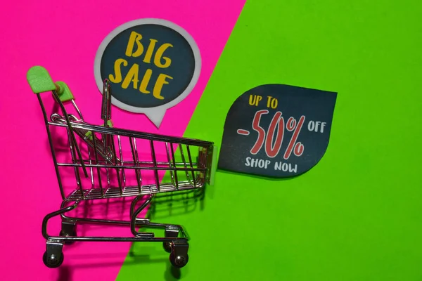 Big Sale and Up To -50% Off Shop Now Text and Shopping cart. Discount and promotion business concept on colorful background