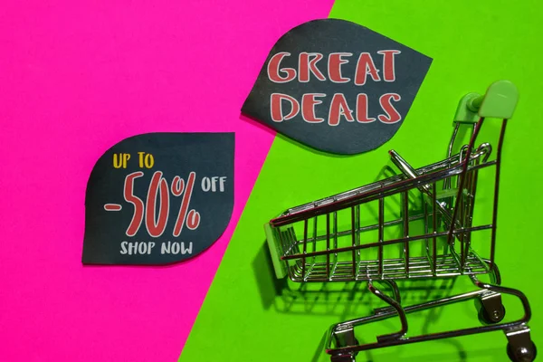 Up To 50% Off Shop Now and Great Deals Text and Shopping cart. Discount and promotion business concept on colorful background