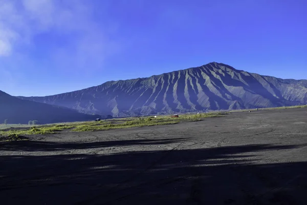 MALANG, EST JAVA, INDONESIA, 2 APRILE 2019: Persone non riconosciute. Paesaggio campo agricolo, la stagione estiva, le piste auto a terra, con un cielo nuvoloso drammatico — Foto Stock