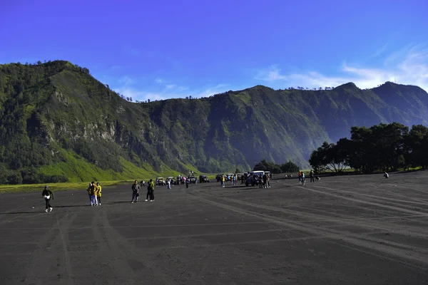 MALANG, JAVA DEL ESTE, INDONESIA, 2 DE ABRIL DE 2019: Personas no reconocidas. Campo agrícola de paisaje, la temporada de verano, las pistas de coches en el suelo, con un cielo nublado dramático — Foto de Stock