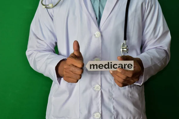 Yeşil Arka Planda Duran Doktor Medicare Kağıt Metnini Tutun Tıp — Stok fotoğraf