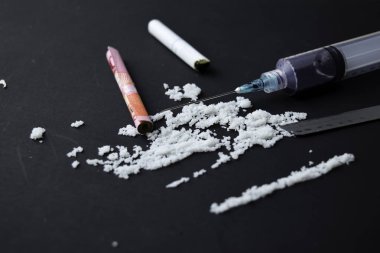 Kokain Seçici odak şırınga ve Endonezya rupiah karanlık masada kullanıma hazır.