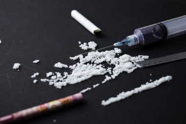 Kokain ve Endonezya rupiası karanlık masada kullanıma hazır. Şırıngaya seçmeli odaklan