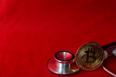 sikke bitcoin ve kırmızı arka plan üzerinde izole bir stetoskop, kripto para çıkarma