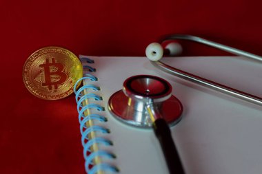 sikke bitcoin, dizüstü bilgisayar, stetoskop ve kırmızı arka plan üzerinde izole bir büyüteç, kripto para çıkarma
