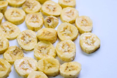 Beyaz arka planda izole edilmiş dilim sarı muzu kapatın