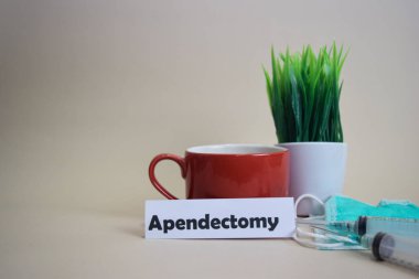 Apendektomi metin, çim tencere, kahve fincanı, şırınga ve yüz yeşil maske. Healtcare/Medikal ve İş kavramı