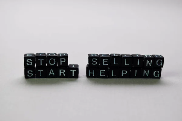 Stop selling start helping on wooden blocks. Motivation and inspiration concept — Stock Photo, Image