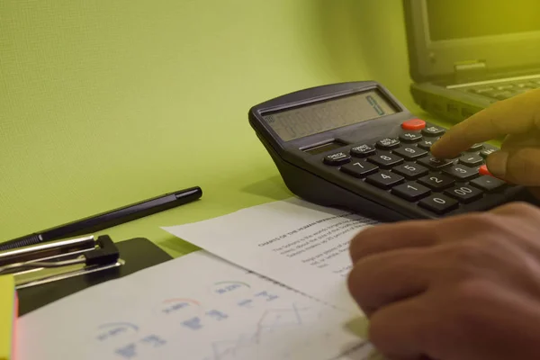 Man calculate budget cost and analysis financial. Selective focus on calculator. Business and finance concept of office desk