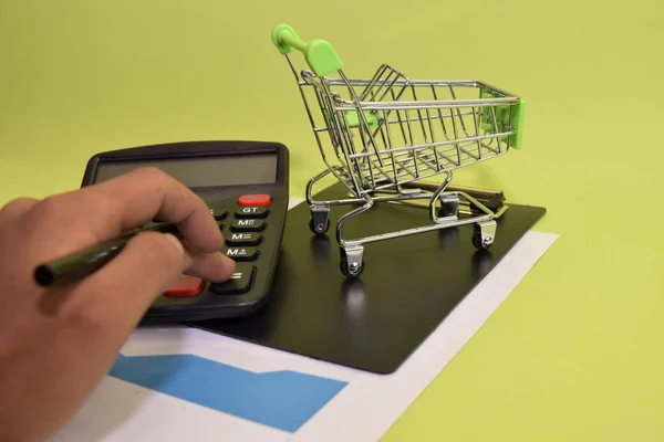 Man calculate budget cost and analysis financial. Selective focus on shopping cart. Business and finance concept of office desk