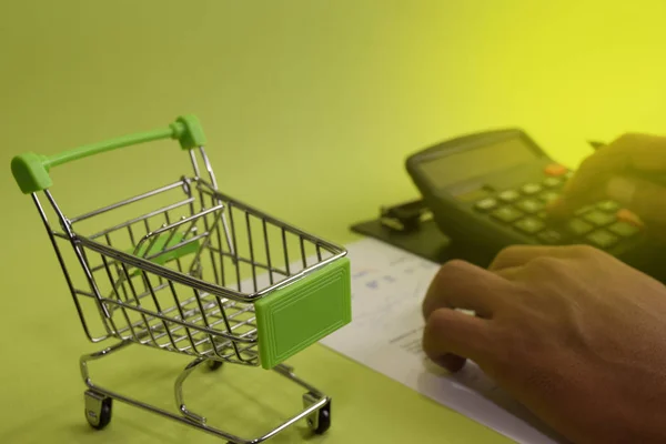 Man calculate budget cost and analysis financial. Selective focus on shopping cart. Business and finance concept of office desk